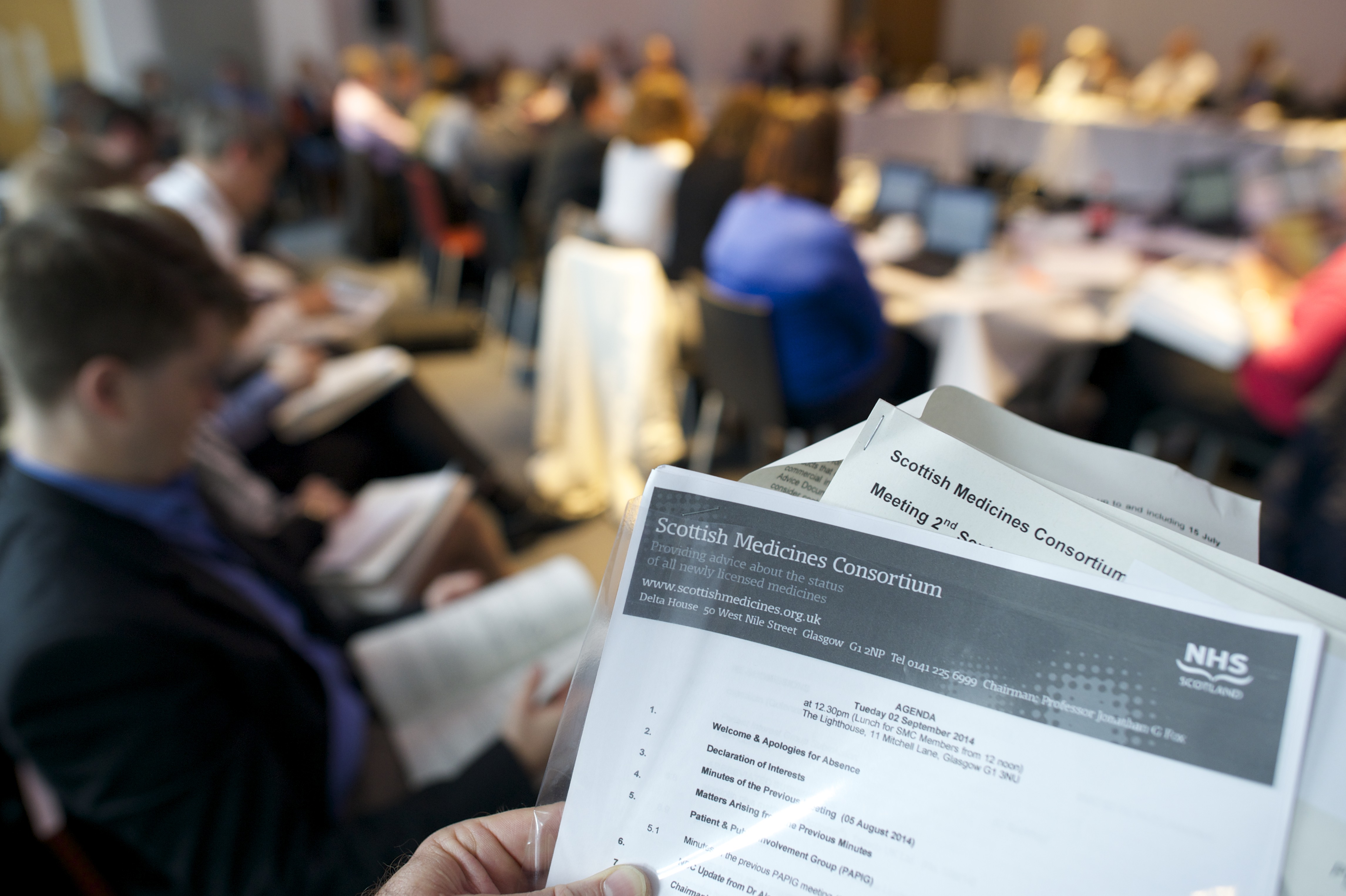 Meeting agenda with meeting in background